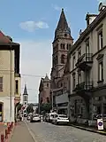 View to a street with reformed church and catholic church in the background