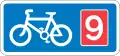 Rectangular, blue traffic sign with a white bicycle symbol and a red square with the number 9 in it.