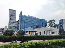 Ho Chi Minh City Stock Exchange (HoSE), old white and new blue buildings]