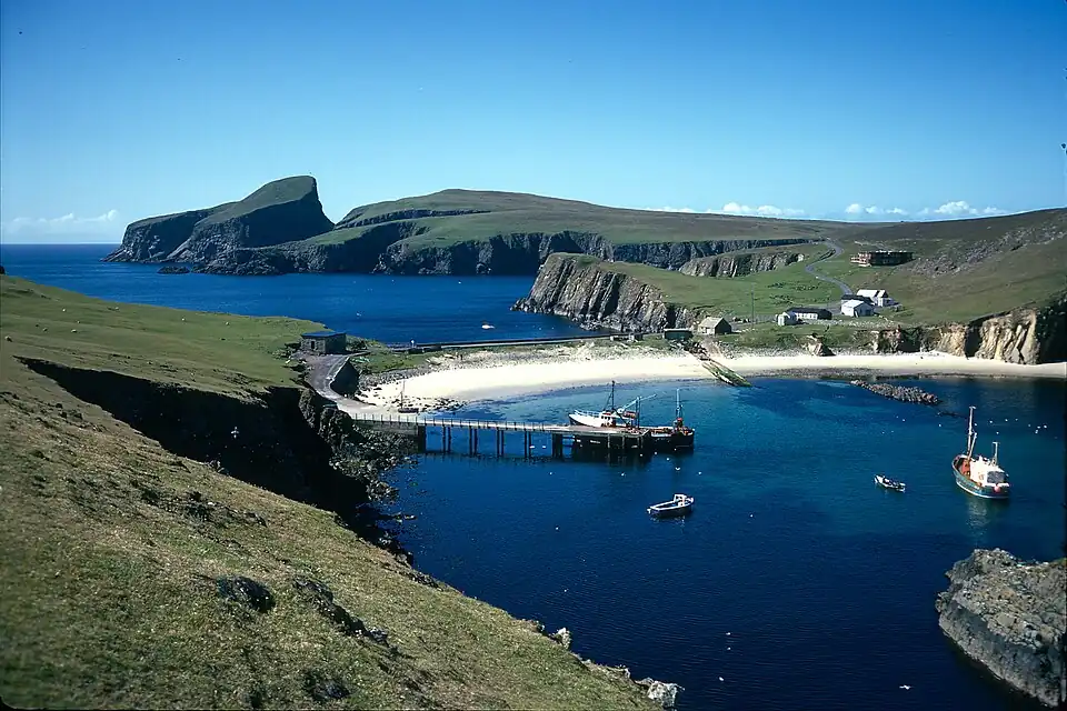 The supply boat Good Shepherd III is tied up on the jetty on Fair Isle, 1974