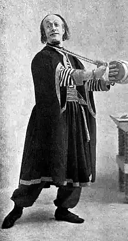 Man in Middle-Eastern costume, playing a small drum