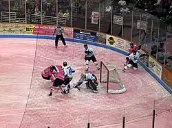 South Carolina Stingrays (in pink jerseys) battle the Toledo Walleye (in white jerseys) for control of the puck in front of the Walleye goaltender. The ice is dyed pink for Pink in the Rink 2010.