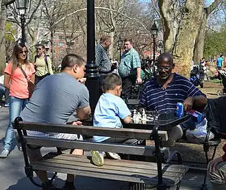 A child playing chess in Washington Square Park, New York City, US