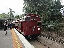 An old train that is red at a station