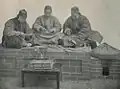 A group of Qing dynasty-era qiánpù stringing cash coins together in 1899.