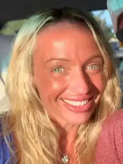 Morin, a tanned woman with dirty blonde hair, smiling.