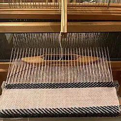 Boat shuttle inside the shed. It floats on the lower warp threads. This only works on horizontal looms. Rhode Island, USA.