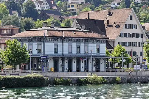 Two-story building with hip roof next to lake