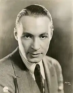 Black and white portrait photograph of a man in 1920s formal attire
