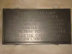 Plaque in Cathedral. The text in English: "Here rests the skull of Jacques Cartier, born at Saint-Malo, the discoverer of Canada, who passed away in 1557. His grave was recovered in this cathedral in the year 1949."