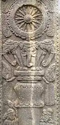 Pillar with elephants supporting a wheel.