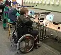 Para shooting with a rifle sitting in a wheelchair