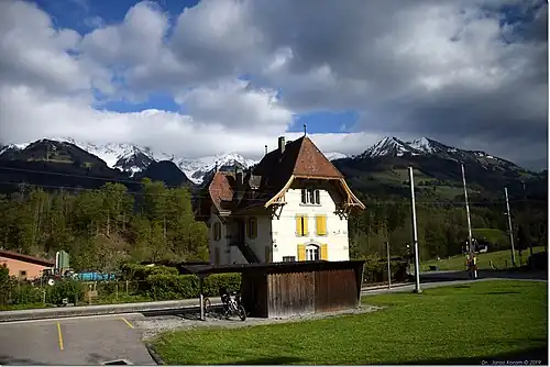 Three-story building next to a single-line track with a passing loop