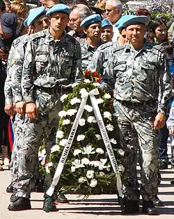 Servicemen with wreaths on the holiday.