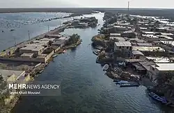 News photo of buildings bordering the Shadegan Ponds