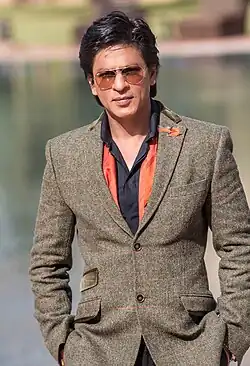 Shah Rukh Khan is looking at the camera.
