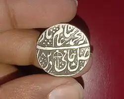 Silver Rupee from the Kingdom of Rohilkhand, minted in Qasba Panipat, struck in the name of Mughal emperor Shah Alam II, with having "saya-e-fazle elah" couplet, Swastika and Parasol marks.