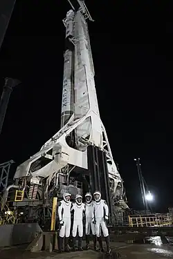 The Crew-3 astronauts stand beneath a Falcon 9 rocket at a countdown dress rehearsal.