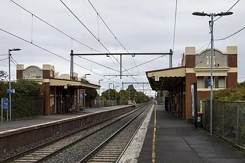 Spotswood station Platform 1 looking south, showing the two station buildings on each platforms