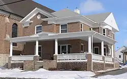Two-story brick building with wrap-around porch
