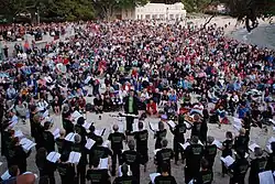 Choir on a beach with conductor and audience
