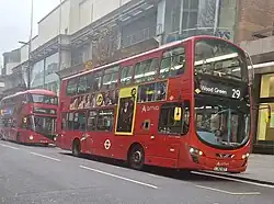 Modern buses bearing TfL branding and current London Red livery