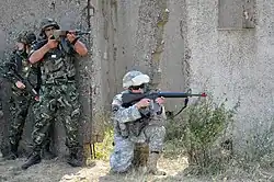 NOVO SELO TRAINING AREA, Bulgaria – Members of the Bulgarian Land Forces 4th Artillery Regiment and U.S. Army Tennessee National Guard 1-181st Field Artillery Battalion provide security for other service members as they sweep through a mock village during military operations in urban terrain training here Aug. 15 as part of Task Force-East.