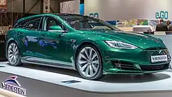 A green station wagon on display at a car show