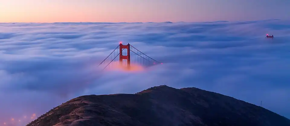 A view of the Golden Gate Bridge from the Marin Headlands on a foggy morning at sunrise