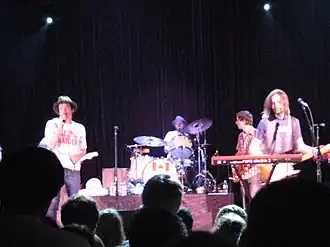 Several men on stage holding instruments