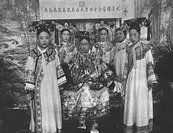 As part of Empress Dowager Cixi's entourage (furthest right).