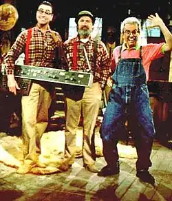 A promotional image, featuring three characters from The Red Green Show on the show's set.