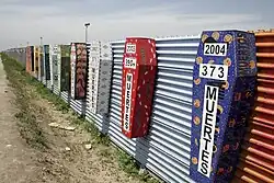 Border at Tijuana, Mexico and San Ysidro, California, United States with memorial coffins for those killed crossing this border. A straight-line border surveyed when the region was thinly populated.