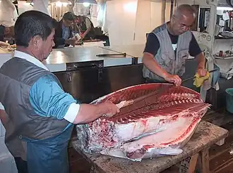 Using a special tuna knife at Tsukiji fish market in Tokyo