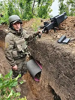 A Ukrainian soldier, equipped with an anti-drone gun, in a trench during the 2022 Russian invasion of Ukraine.