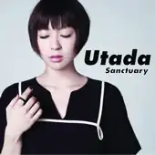 A portrait of Hikaru Utada standing in front of a light-blue screen. She is wearing black clothing and looking at her left hand.