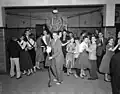 High school prom including a male (center) wearing Teddy Boy style suit with bootlace tie, 1956.