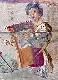 1st century AD, Herculaneum. Woman playing kithara; 2 straps are visible that holds the instrument up while she uses both hands to play (one blue, one yellow).