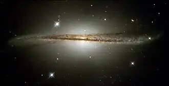 A spiral galaxy, ESO 510-G13, was warped as a result of colliding with another galaxy. After the other galaxy is completely absorbed, the distortion will disappear. The process typically takes millions if not billions of years.