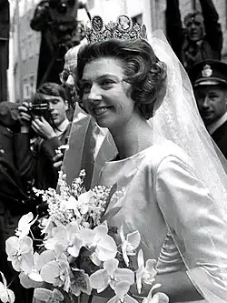 Black and white photo of a woman carrying flowers at her wedding