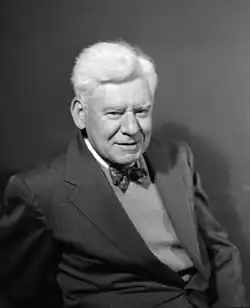 An older white man in formal dress, wearing a bow tie.