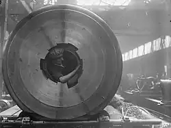 A female worker cleans the breech threads of a 15-inch gun from inside the barrel in the Coventry Ordnance Works during WWI