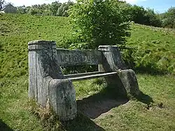 A wooden bench located on the footpath